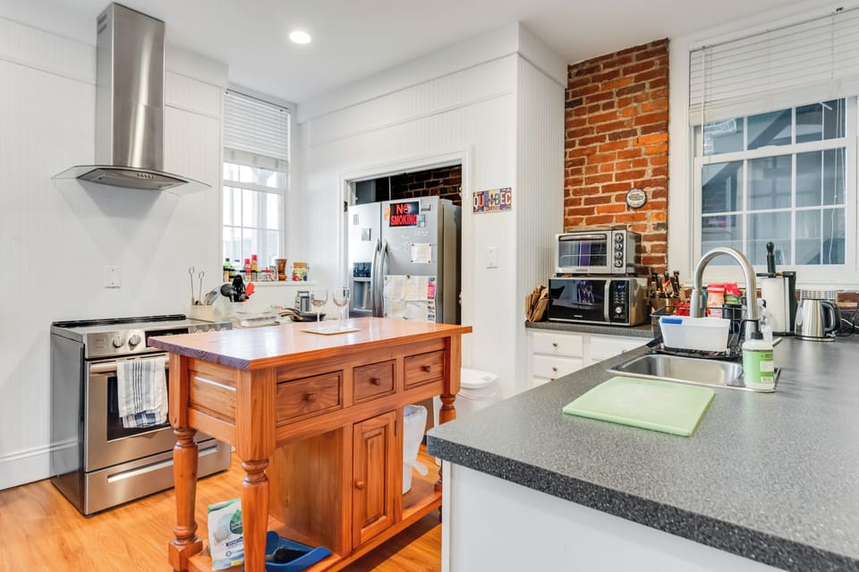 Kitchen: Whip up culinary delights in this stylish, modern kitchen with charming brick accents!