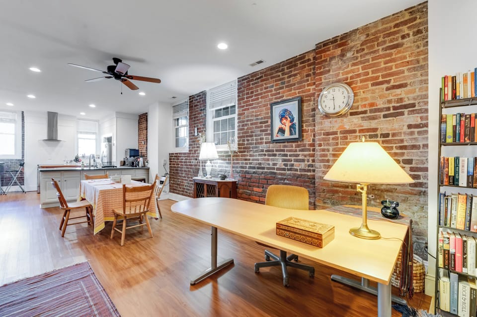 Charming Living Area/Work Space: Exposed brick walls complement a bright space perfect for relaxation!