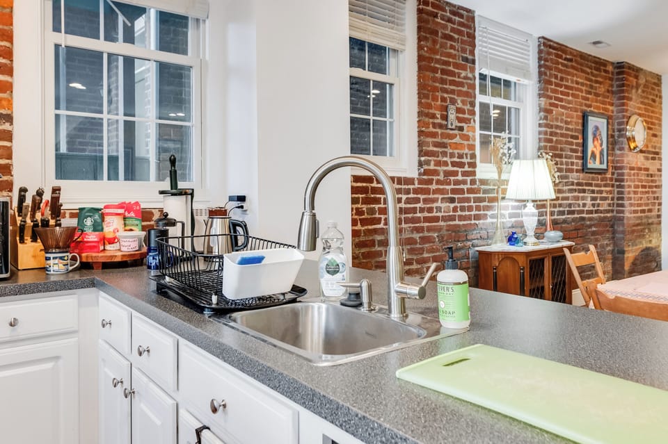 Kitchen: Stylish design meets function with exposed brick and modern appliances for culinary adventures!