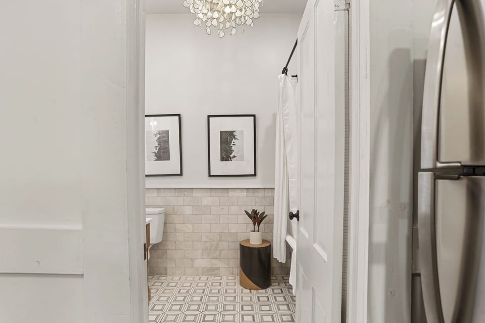 The kitchen leads directly to a bright, stylish bathroom—everything conveniently close by.