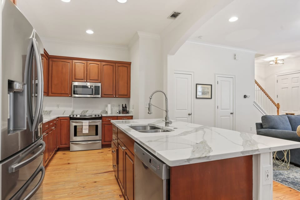 Clean white counters and warm wood cabinets create a welcoming space that's both functional and stylish.