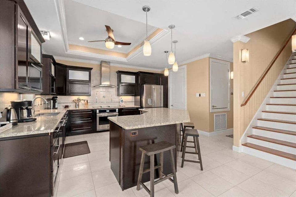 Spacious chef's kitchen with breakfast bar seating and open floor plan.