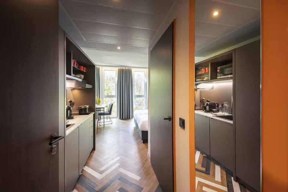 Step inside a streamlined studio with kitchenette and airy window.