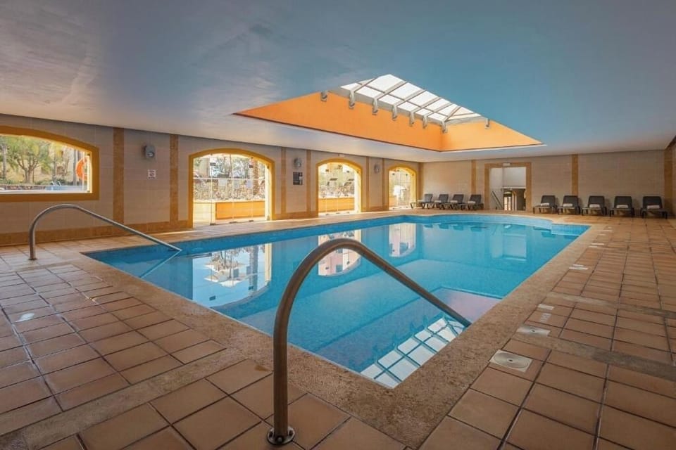 Swim laps in a spacious indoor pool with gentle light