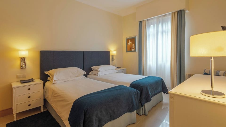 Unwind in crisp twin beds with soft, glowing lamps.