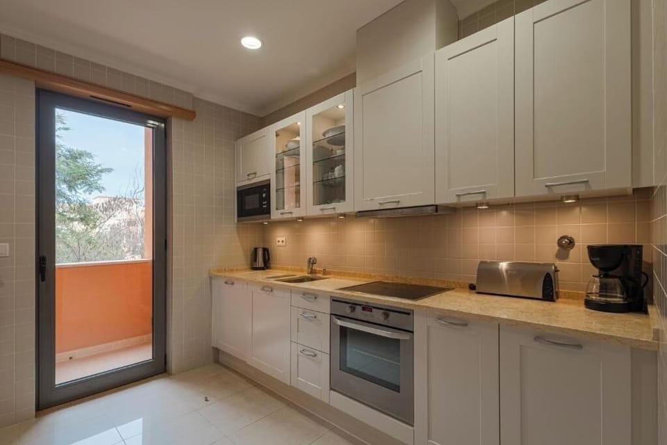 Enjoy sunlit cooking with balcony access and sleek cabinetry.