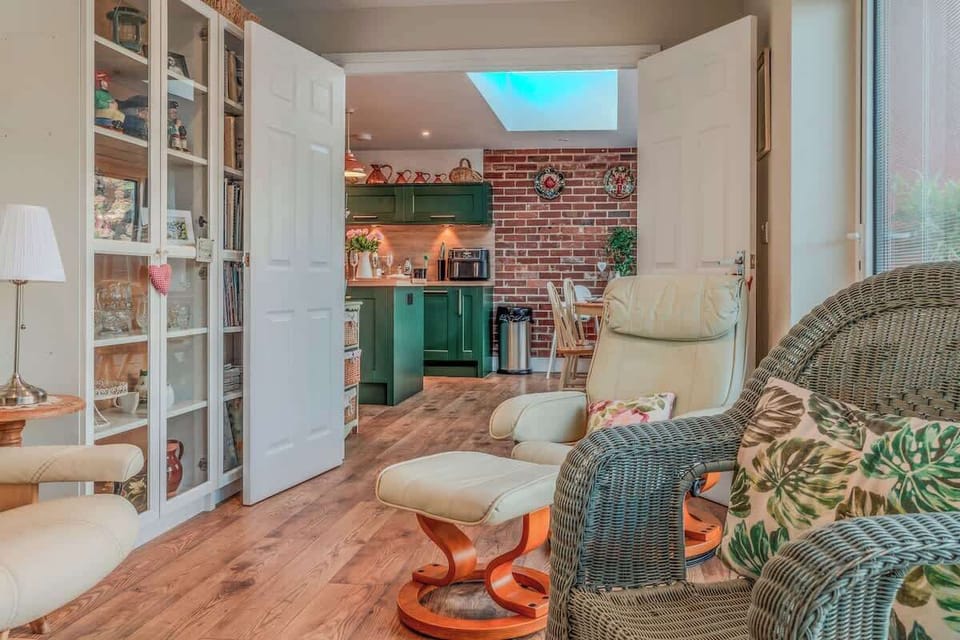 A light-filled sunroom overlooking the dining space, creating a calm and comfortable area to sit back and relax while remaining part of the home’s open and social layout