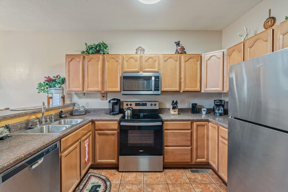 Your fully equipped kitchen features stainless steel appliances and warm wood cabinets, ready for everything from morning coffee to home-cooked meals.