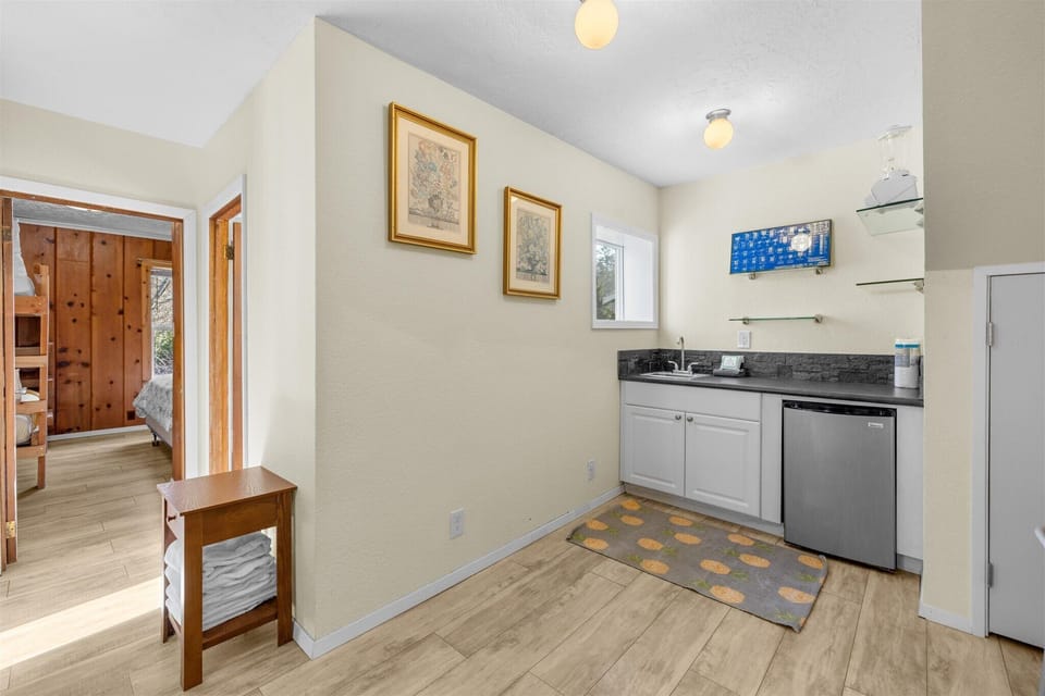 Your modern kitchen features granite countertops, stainless appliances, and open shelving—perfect for preparing meals while staying connected with the mounted TV.