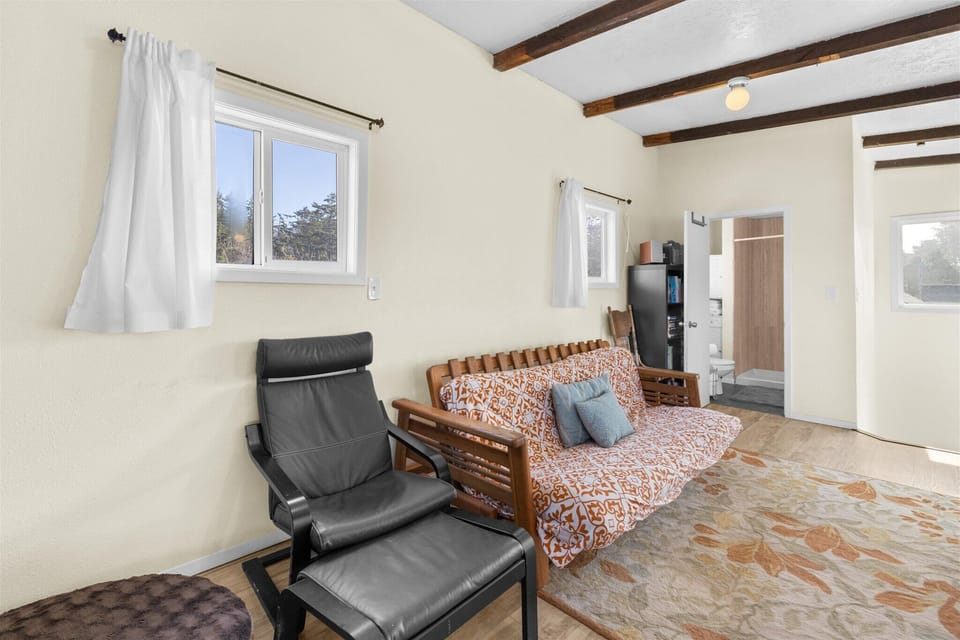 Unwind in your cozy living room with exposed wooden beams and comfortable seating for peaceful moments.