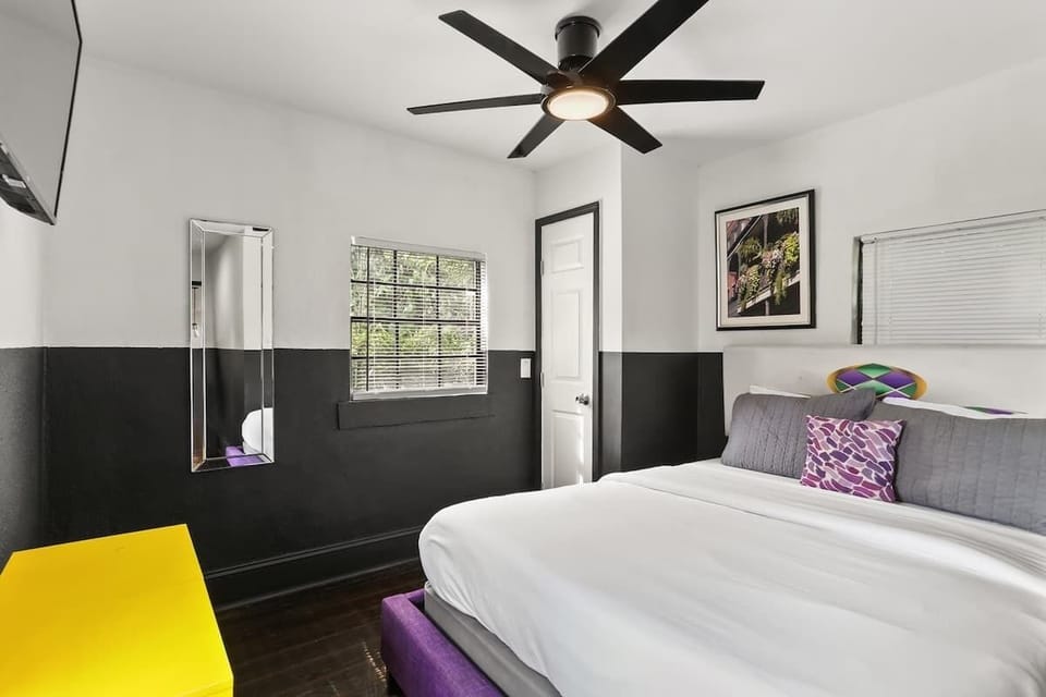 Bright and comfortable bedroom featuring a plush bed, ceiling fan, and clean modern design—an inviting space to unwind and get a great night’s rest after a day in the city.