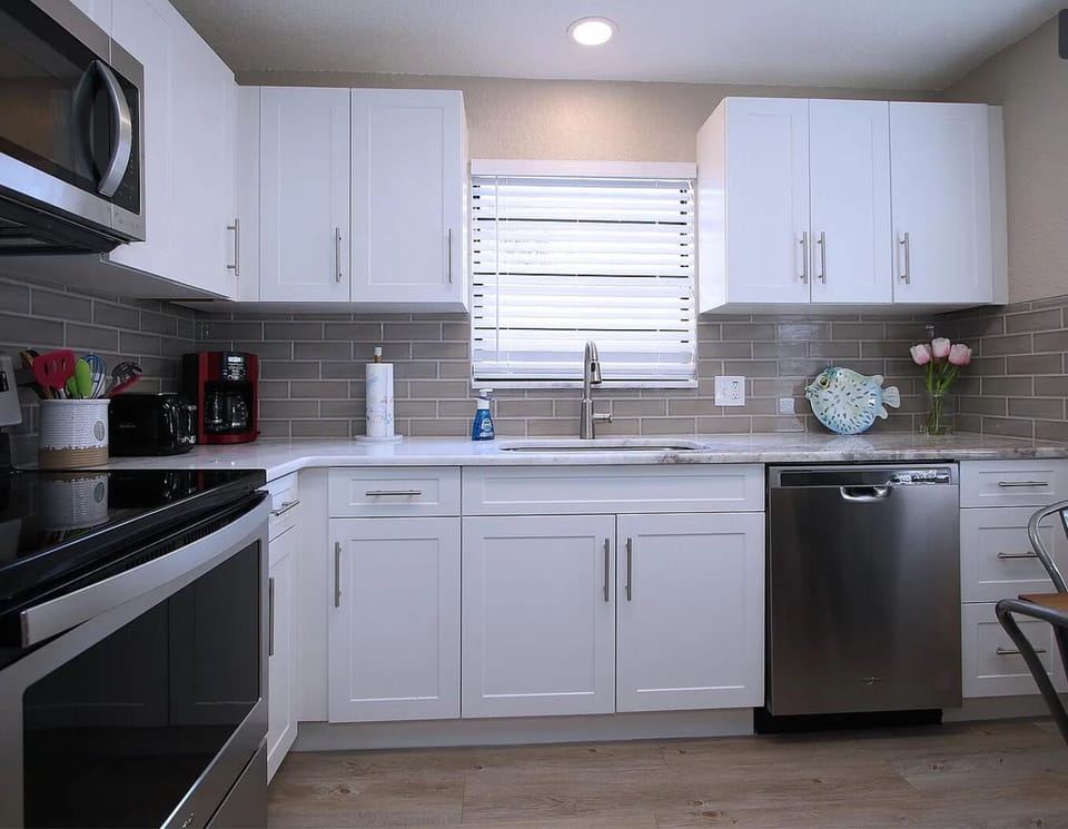 Stone countertop, large sink, & classic tile backsplash make cooking/cleanup fun