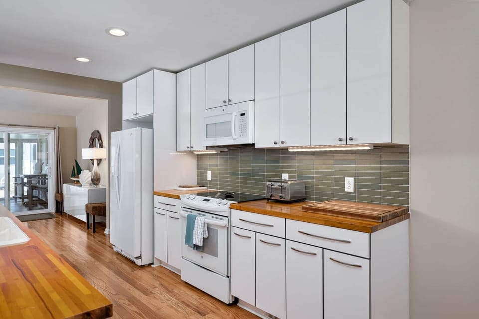 The fully equipped kitchen features wood countertops, stainless steel appliances, and everything y