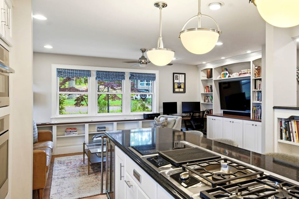 Gas cooktop on island with pendant lights and breakfast bar