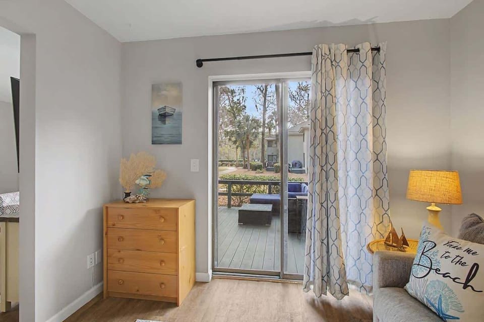 Step onto your private balcony from this bright room, where morning coffee meets peaceful views and coastal-inspired decor creates your perfect retreat.