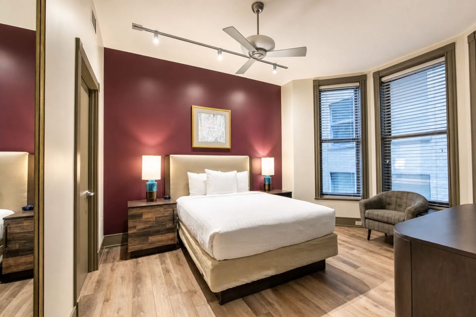 Unwind in a crisp, quiet bedroom with modern lighting.