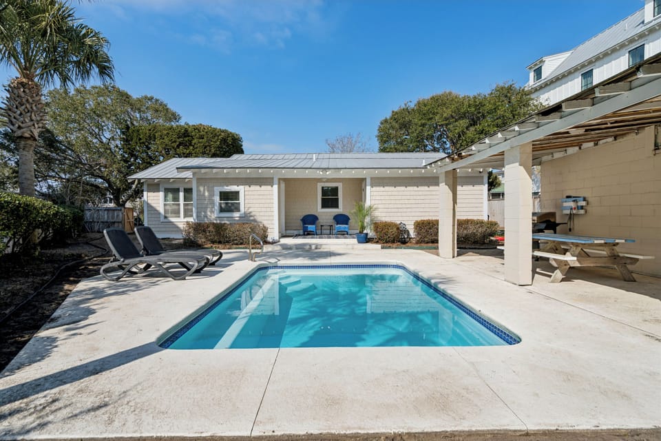 Dive into your private oasis with a crystal-clear pool surrounded by comfortable loungers, all nestled in a peaceful backyard paradise.
