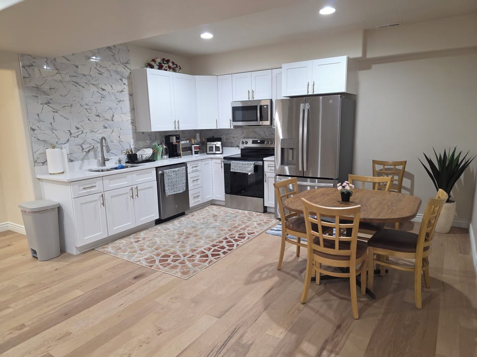 Fully loaded modern kitchen with stainless appliances, big dining table, and ton