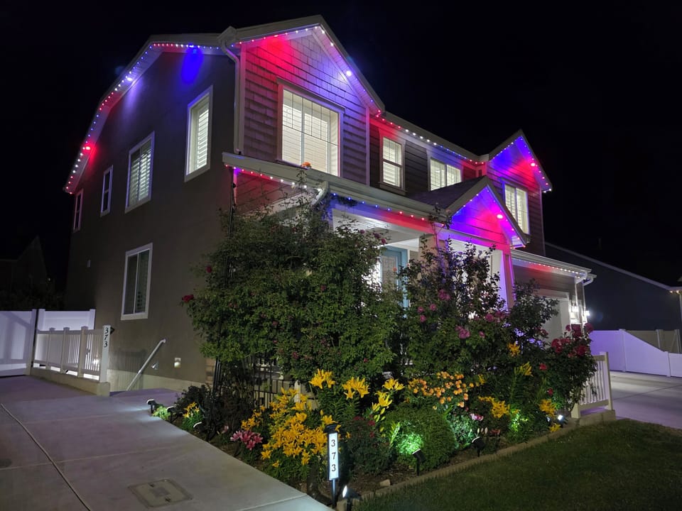 Magical nighttime glow with colorful LED lights on home & gardens.