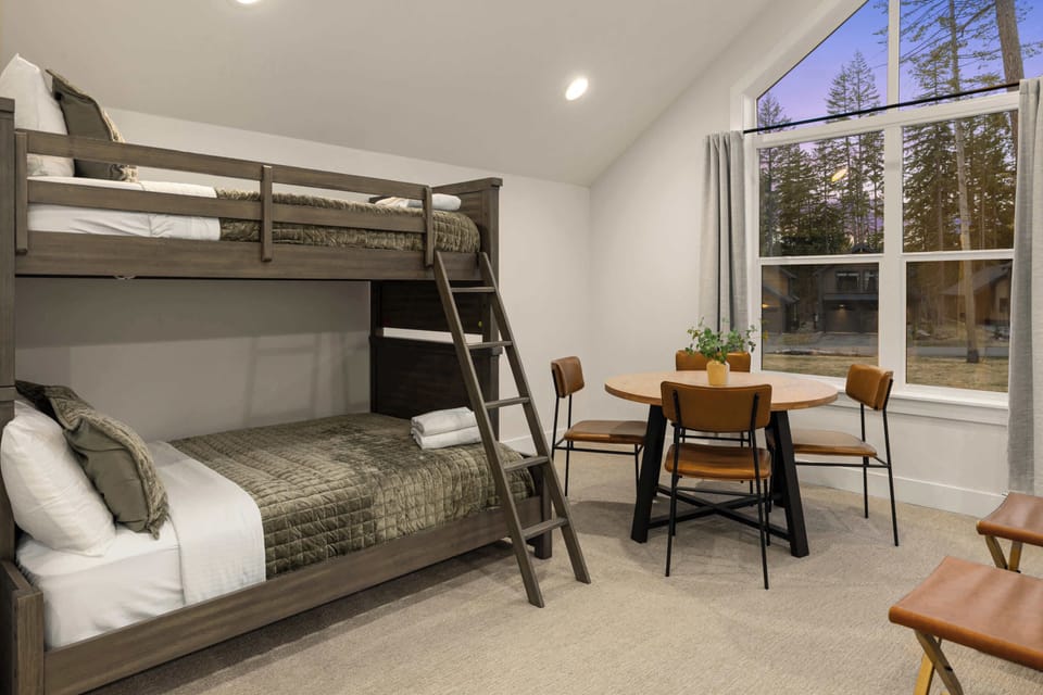 Upstairs sleeping area with bunk beds and a small table perfect for games or quiet time.