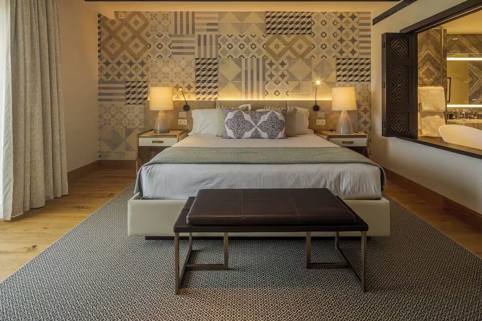 Sink into crisp linens beneath warm lights and designer tiles.