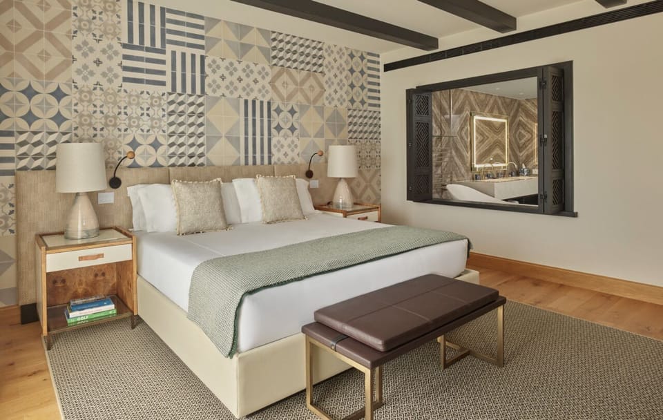 Drift off in luxe linens with a peek into the spa bath.