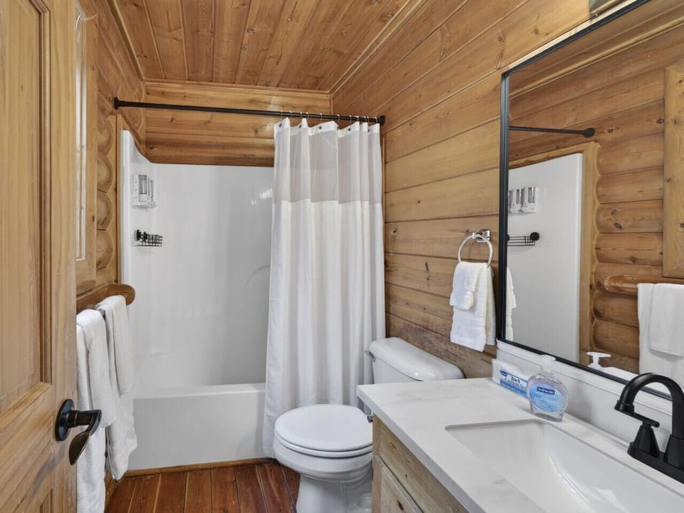 En-Suite Bathroom | Single Vanity & Shower Tub Combo | Fresh Towels and Toiletries