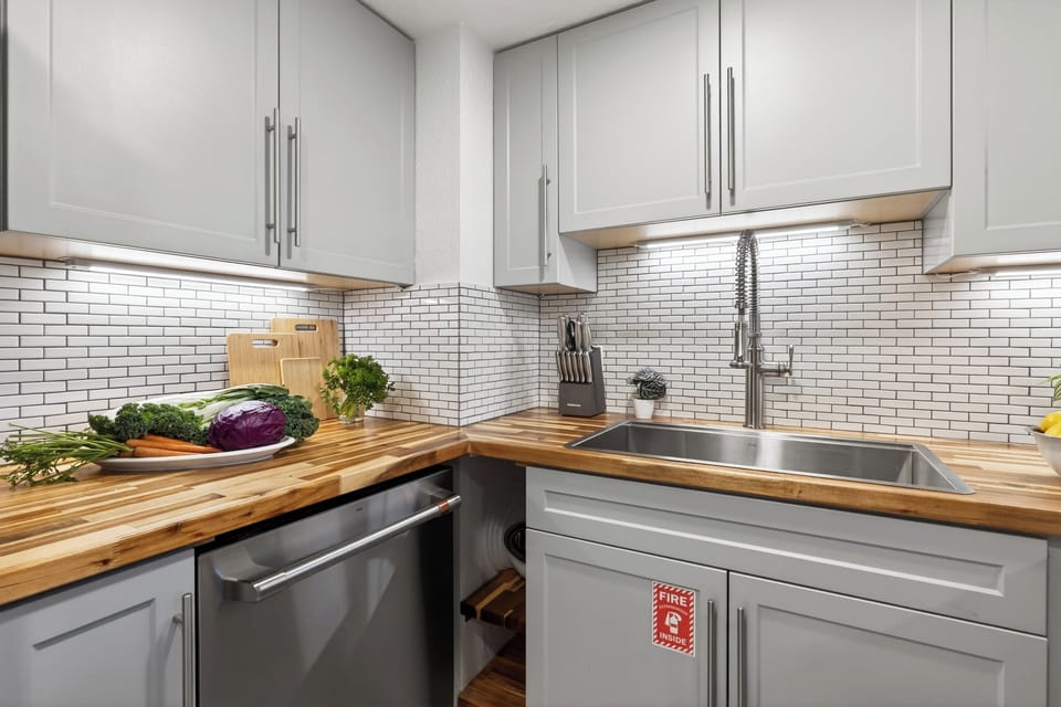 Sleek, fully equipped kitchen with butcher-block counters and modern finishes.