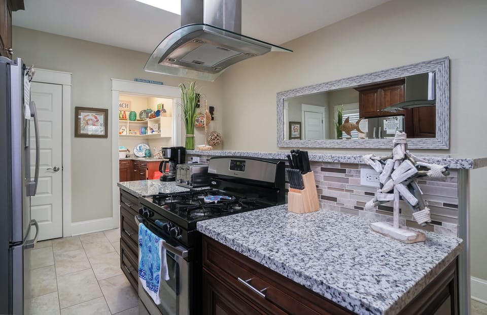 Granite kitchen counters and modern appliances in fully stocked Galveston vacation rental kitchen.