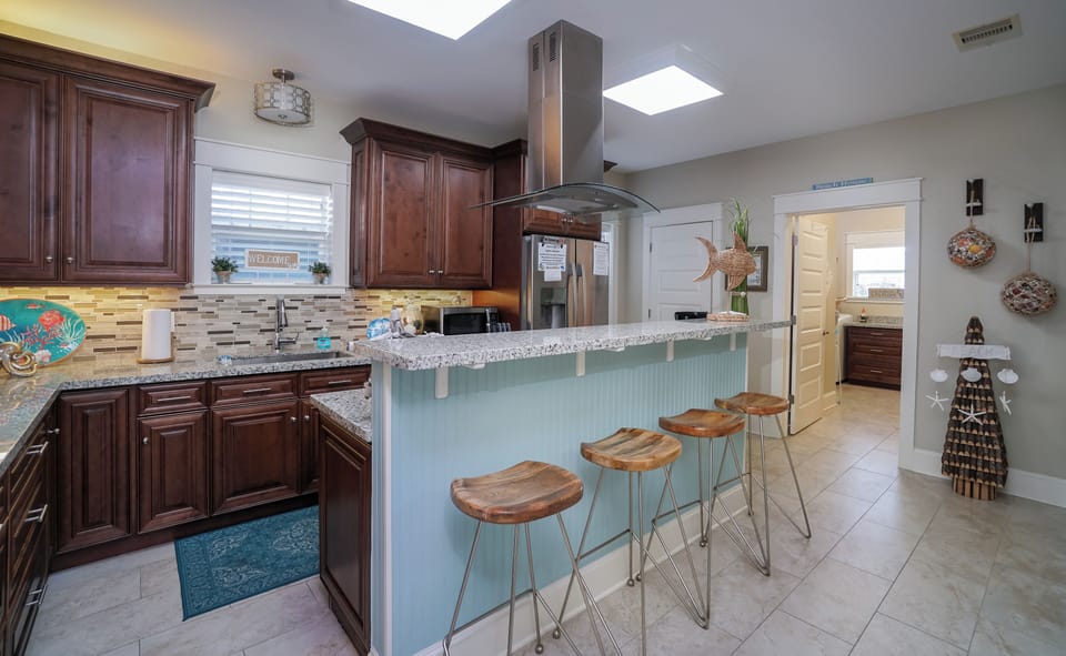 Large fully equipped kitchen with granite countertops and bar seating in Galveston beach house rental.