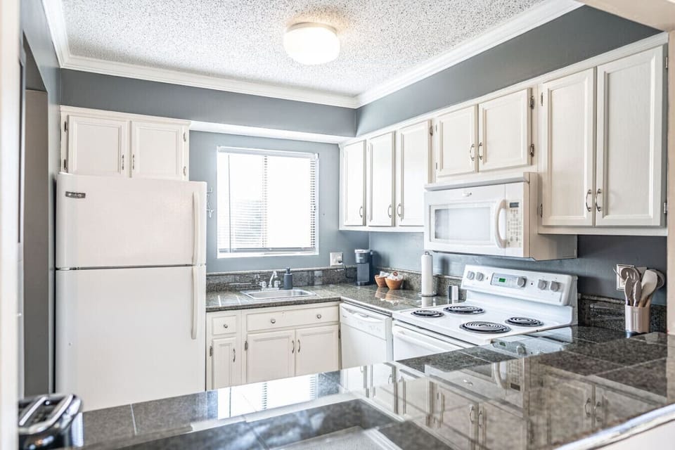 Bright kitchen featuring granite countertops, full-size appliances, and everything needed for home-style cooking.