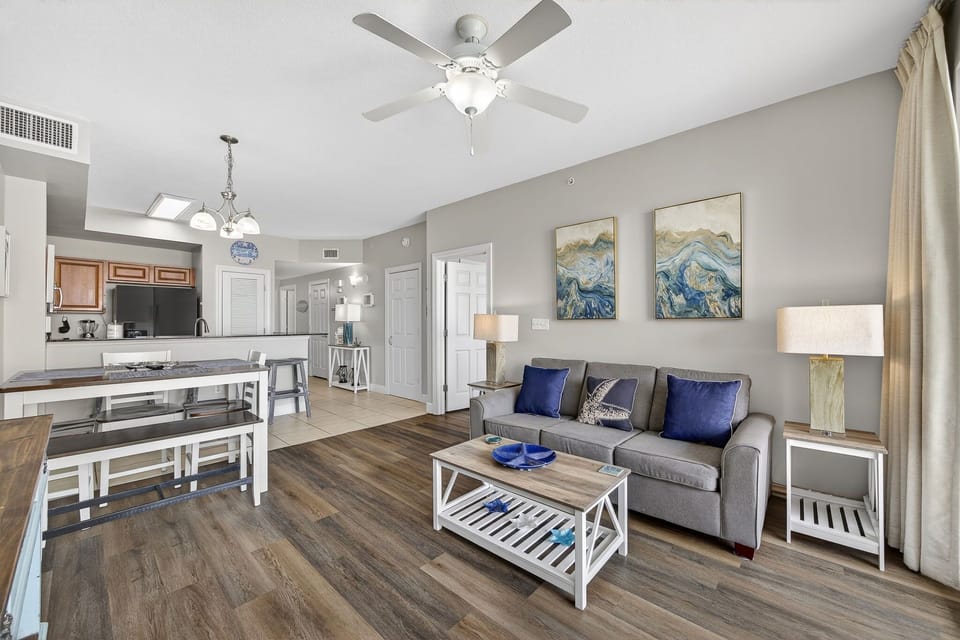 Relax in your open-concept living space with coastal artwork and modern comforts creating the perfect beach getaway atmosphere.