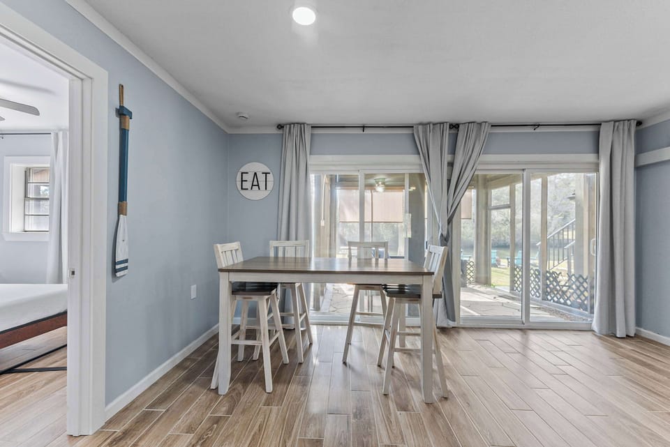 Dining area with table seating and sliding doors leading to the screened patio