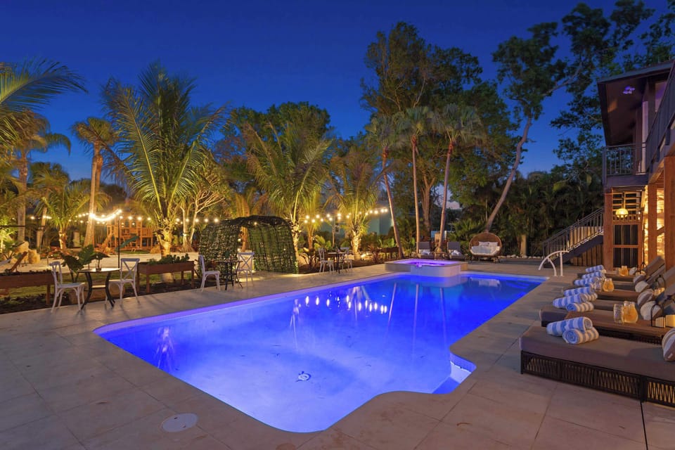 Outdoor Oasis: Dive into relaxation by the pool, surrounded by lush palms and twinkling lights!