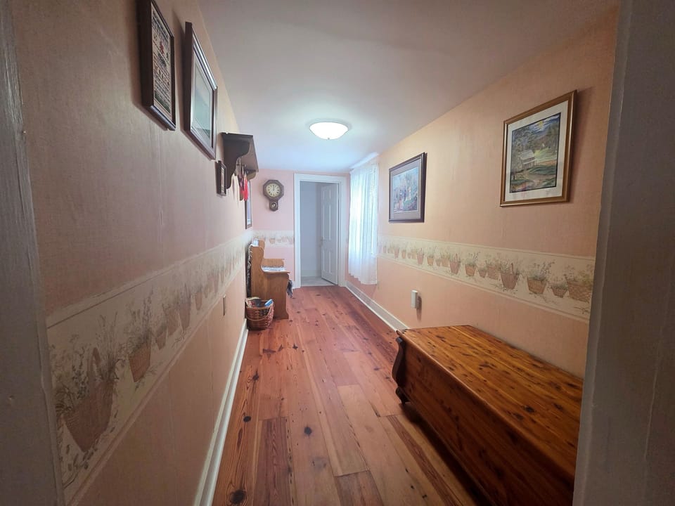 The upstairs hallway is located at the top of the steps, connecting the bedrooms and bathrooms.