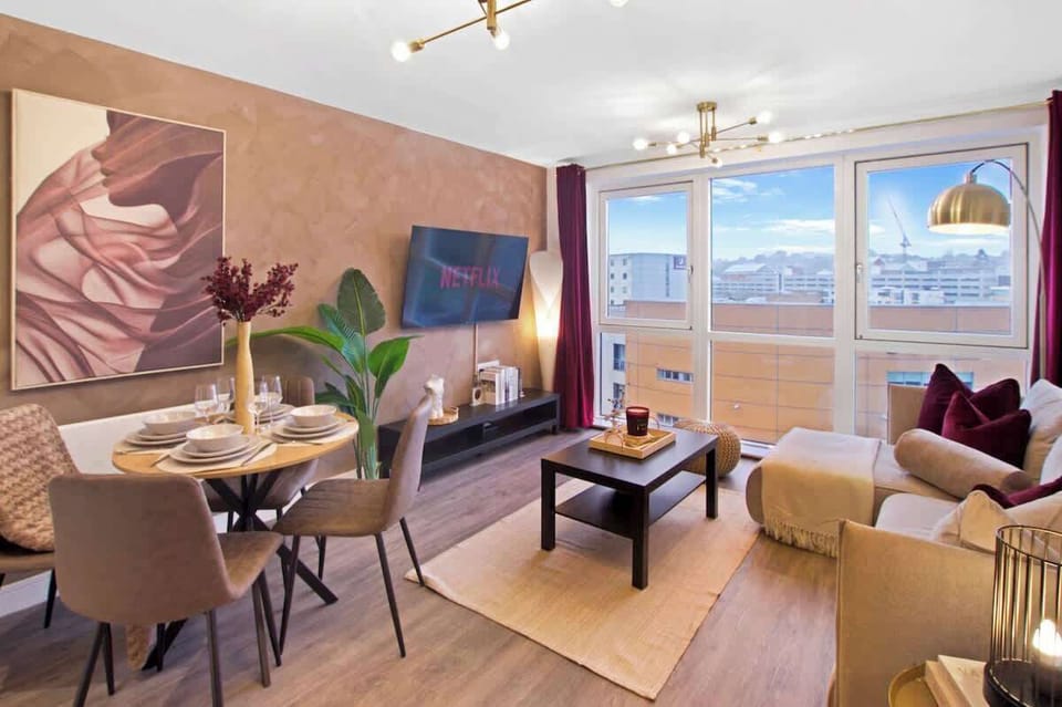 Beautifully designed living room with Smart TV, comfortable seating, and large windows creating a bright and relaxing space.

