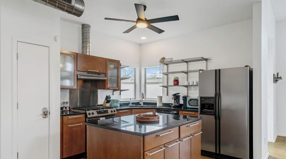 Prep-friendly kitchen layout with open shelves and central island.