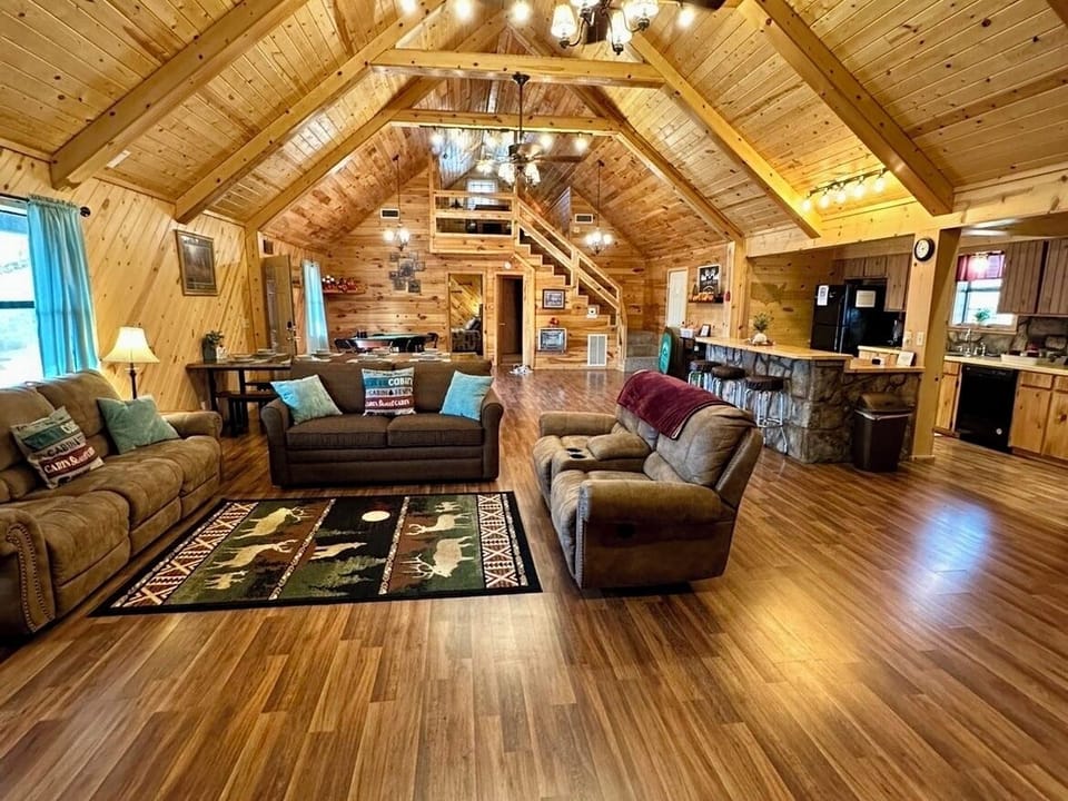 Open living room and showcasing the stairwell that goes up to the 2nd loft. 