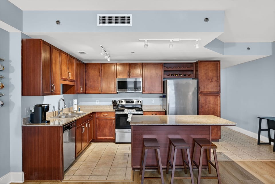 Your fully-equipped kitchen awaits with rich wood cabinetry, granite counters, and stainless steel appliances—perfect for creating memorable meals together.