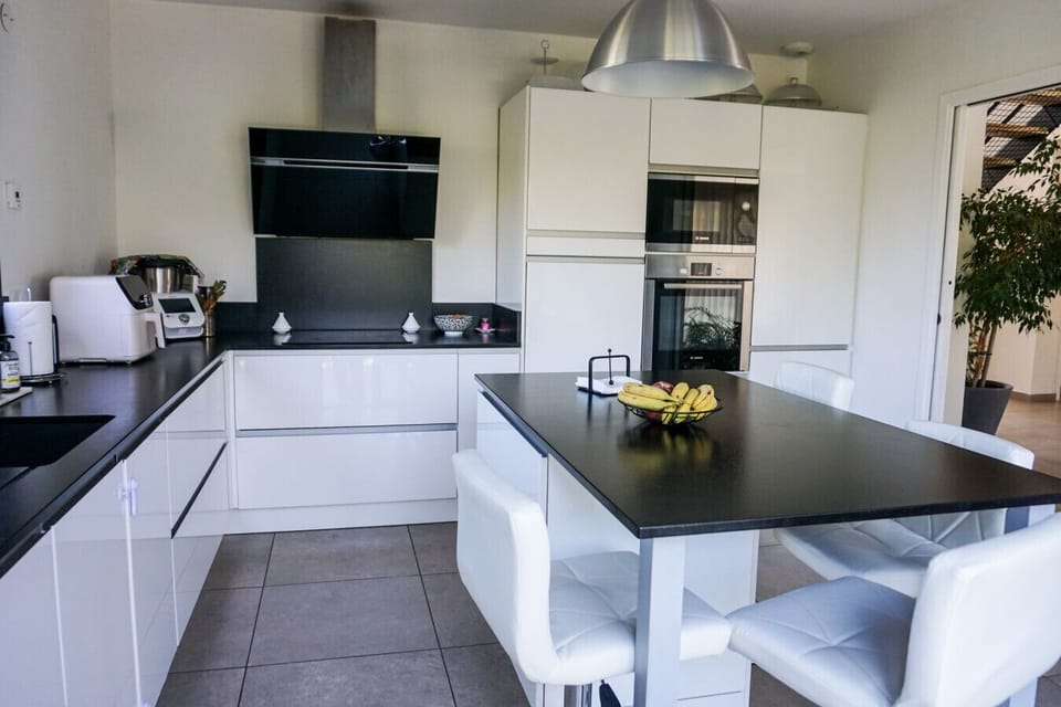 Cuisine moderne entièrement équipée – plan de travail spacieux, hotte et four encastrés, îlot central, tout pour vos repas de vacances