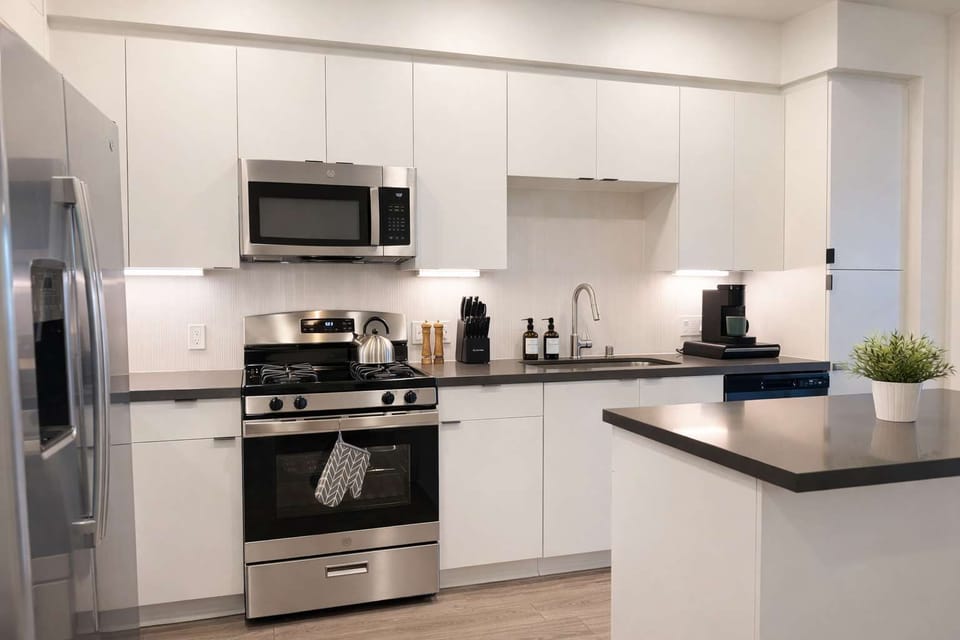 Experience extended comfort with a fully equipped kitchen featuring a coffee machine, stovetop, and microwave—everything you need for a seamless long-term stay