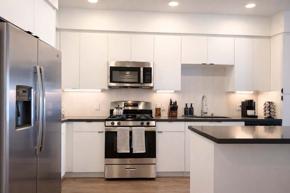 Experience extended comfort with a fully equipped kitchen featuring a coffee machine, stovetop, and microwave—everything you need for a seamless long-term stay