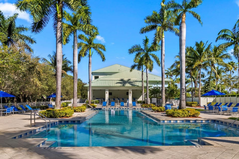 Resort pool overlooking the clubhouse, featuring ample seating and a bright, open layout.