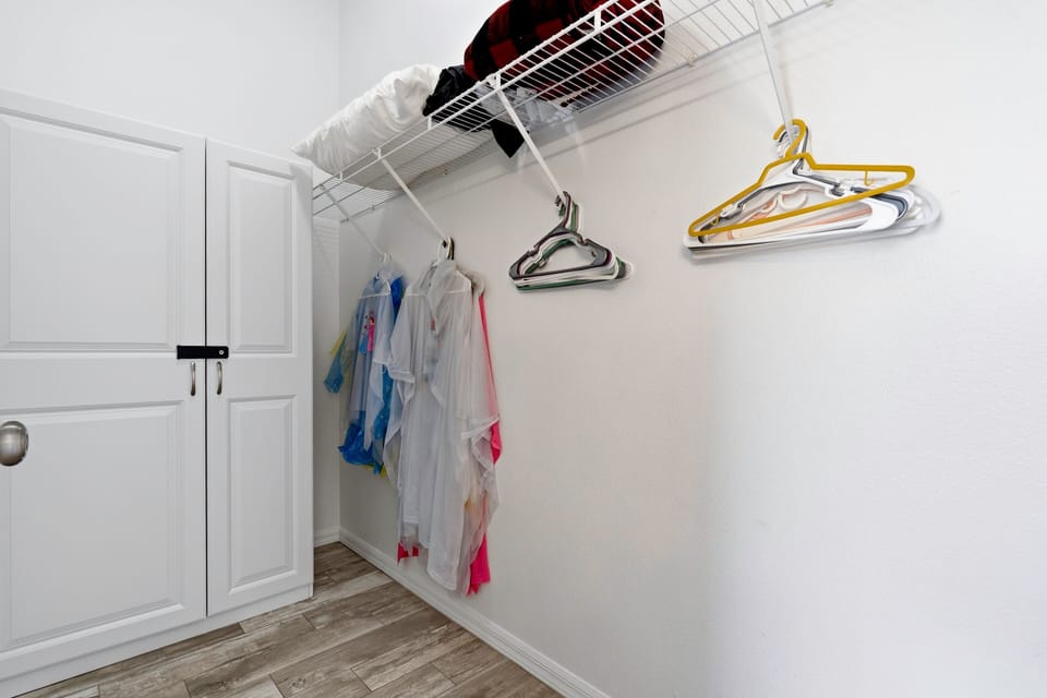 Spacious walk-in closet with hanging space and shelving.