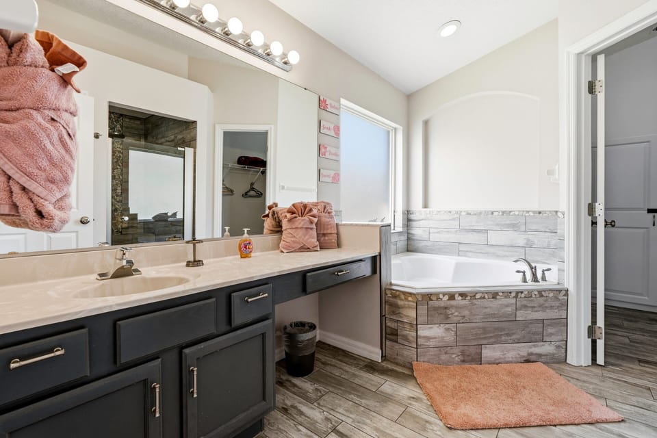 Spacious bathroom with double vanity, soaking tub, and walk-in shower.