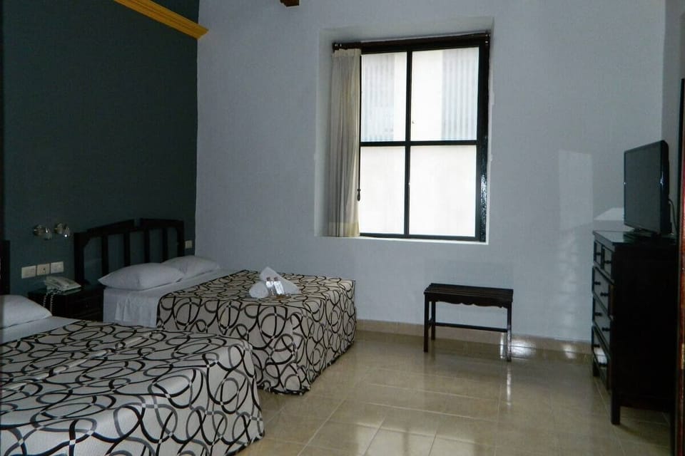 Rest peacefully in a simple room with twin beds and TV.