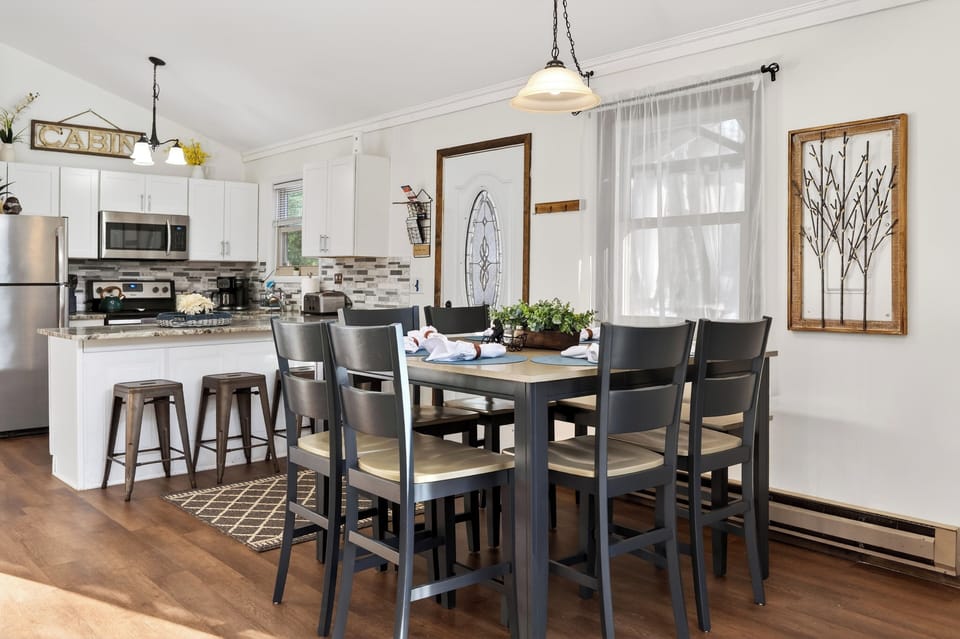 Dining area with a dark wood table set for a meal, adjacent to the kitchen.