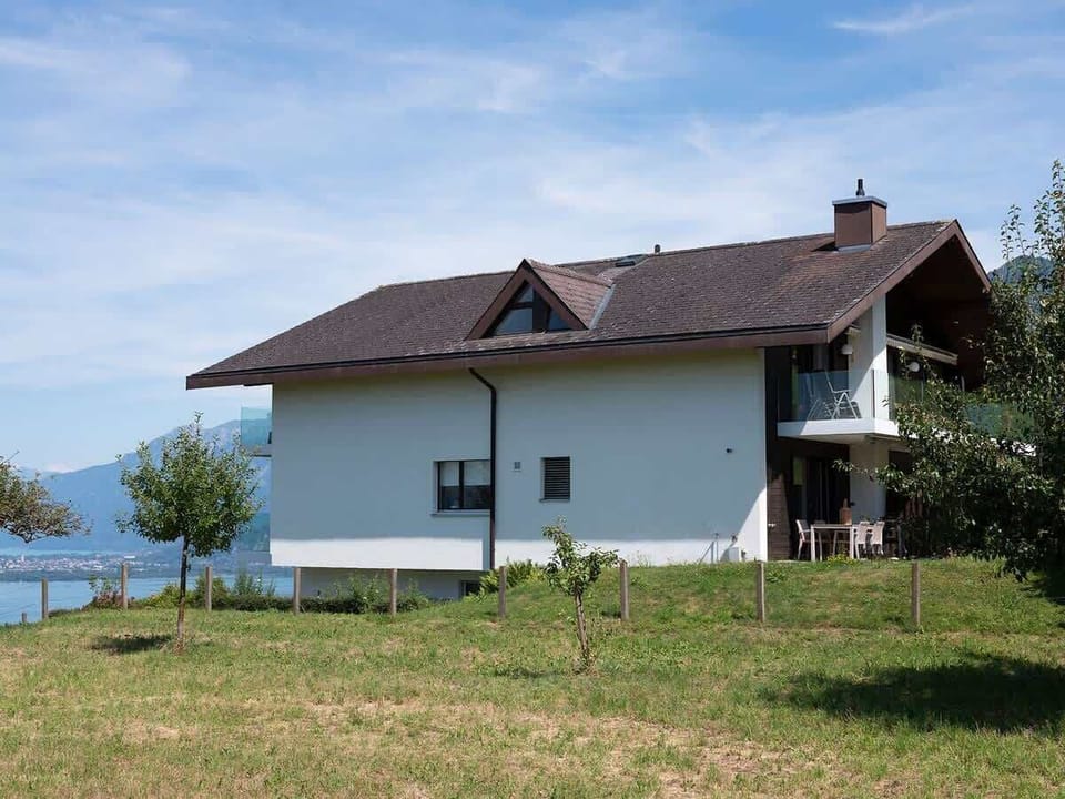 So this is our house viewed from West, our appartment is on the ground floor, next to an open field. The glass balconies to the front offer 180 degree views over the lake. In the distance you can see Interlaken.