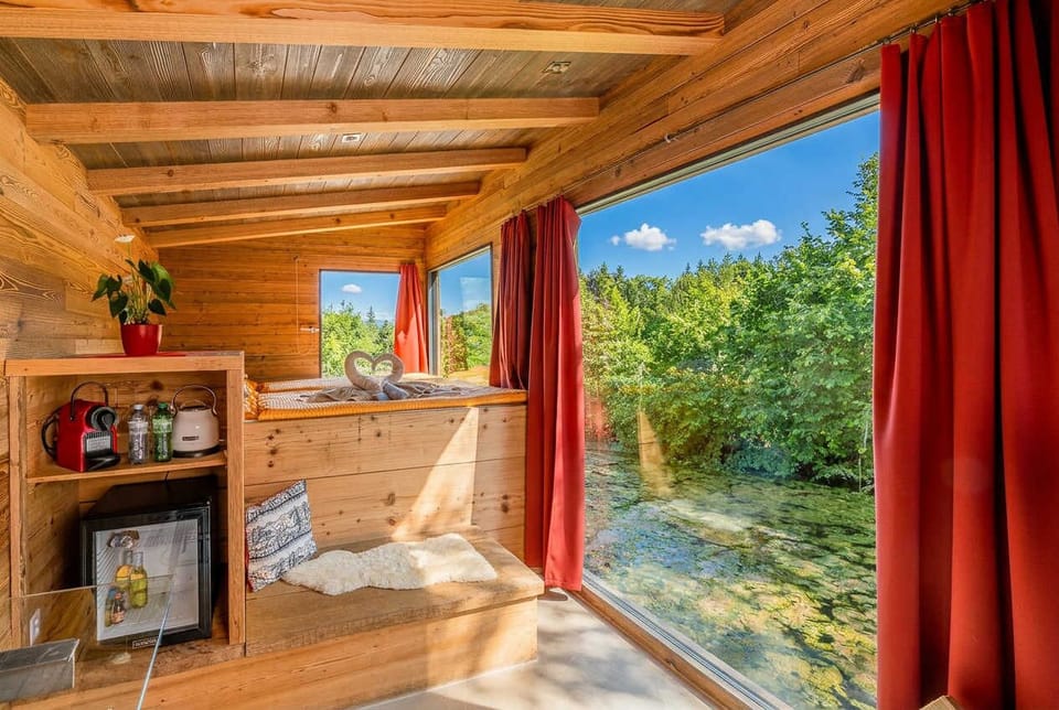 Cozy wooden interior with large window and peaceful lake view