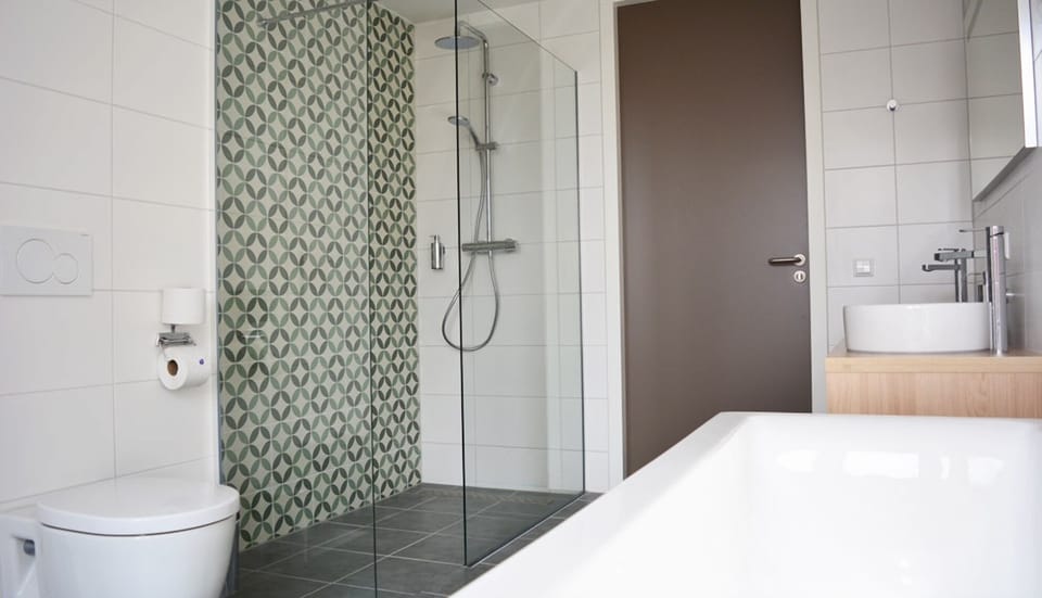 Refresh under a sleek rainfall shower in a spotless bath.